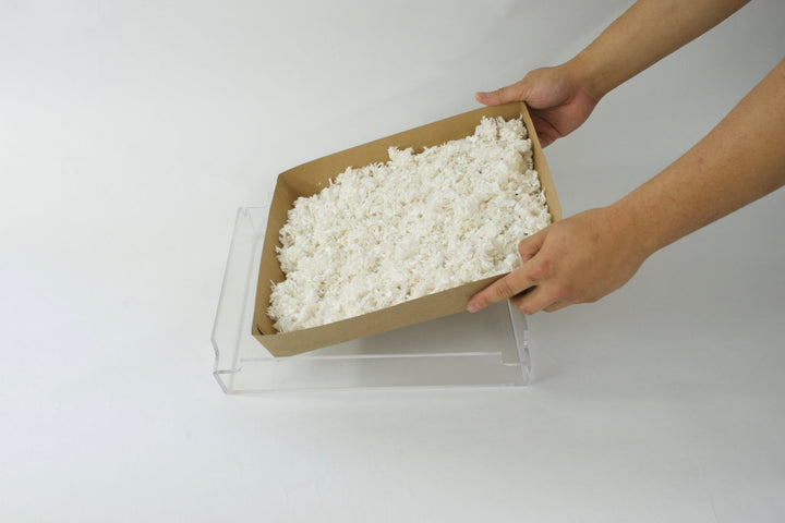 Guinea Colony Pre - Filled Disposable Kitchen Liner Refills with Paper Bedding (4 - Pack) - Critter Colony Club - Person holding placing a kitchen liner pre - filled with white paper bedding. This is perfect for inside a guinea pig cage.